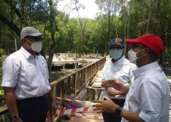 IZHAM Hashim (kiri) mendengar taklimat mengenai projek pembinaan Taman Rekreasi Mangrove Point di Pelabuhan Klang, Selangor.