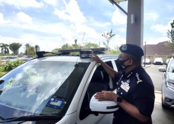 MAT Kasim Karim menunjukkan kamera sistem iCOPS pada majlis memperkenalkan iCOPS di pekarangan Hotel Seri Malaysia, Kangar, Perlis. - UTUSAN/SYED AZLAN SAYID HIZAR