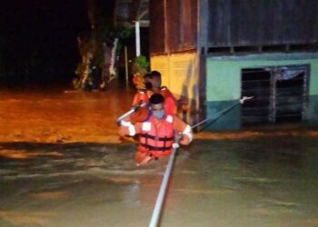 ANGGOTA APM yang membantu mangsa banjir berpindah di Kampung Tanjung Pari, Baling malam semalam.