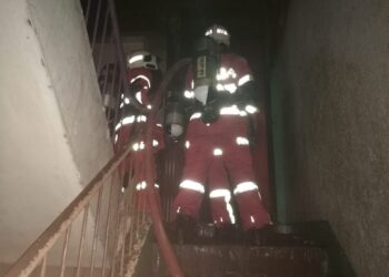 ANGGOTA bomba memadam kebakaran yang mengakibatkan seorang bayi rentung di sebuah rumah atas kedai di Pusat Bandar Sandakan semalam. - IHSAN Bomba