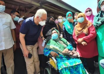 NAJIB Tun Razak menemui seorang penduduk, Tom Deris sewaktu melawat Jeti Nelayan Kampung Hailam, Tanjung Kling, Melaka. - UTUSAN/AMRAN MULUP