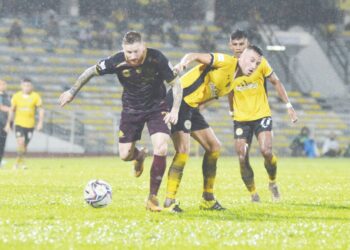 PEMAIN Terengganu, Lee Tuck (kiri) melepasi asakan dua pemain Perak dalam perlawanan Kumpulan B Piala Malaysia di Stadium Perak, Ipoh, malam kelmarin. - UTUSAN/ZULFACHRI ZULKIFLI