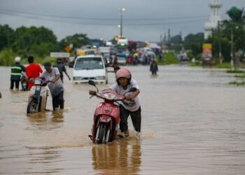 PENGGUNA jalan raya meredah air dalam kejadian banjir yang di pekan Pokok Sena, Alor Setar hari ini. - UTUSAN/SHAHIR NOORDIN