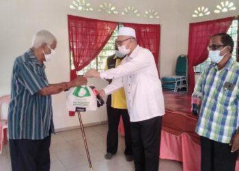 RAZMAN Zakaria (tengah) menyampaikan sumbangan Deepavali kepada penduduk di Semanggol dekat Bagan Serai hari ini.  - UTUSAN/WAT KAMAL ABAS