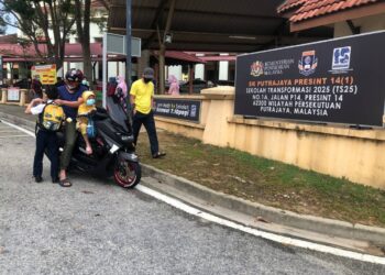 SEBAHAGIAN ibu bapa menghantar anak mereka ke sekolah hari ini pada hari pertama sesi persekolahan di Putrajaya. - UTUSAN/SUBKHI SUDARJI