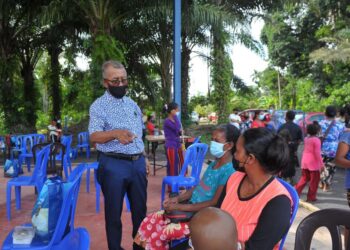 ISMAIL Abd. Muttalib beramah mesra dengan penerima bakul makanan pada Majlis Ramah Mesra Komuniti Orang Asli Sungai Jempol di Maran, Pahang. - UTUSAN/SALEHUDIN MAT RASAD