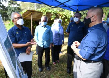 SAARANI Mohamad (kanan) mendengar taklimat mengenai cadangan pembinaan RPT Kampung Ngor di Padang Rengas hari ini. - UTUSAN/ASLIZA MUSA