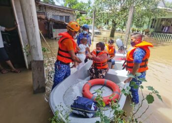 ANGGOTA APM Kota Setar membantu memindahkan mangsa banjir di Kampung Alor Jawi, Alor Setar, Kedah.