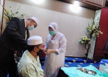 DR. IZANI Husin membantu petugas memberikan suntikan dos penggalak kepada Pengerusi Jawatankuasa Pembangunan Belia, Sukan dan Badan Bukan Kerajaan (NGO) Kelantan, Wan Roslan Wan Hamat di Kota Bharu hari ini. - UTUSAN/ROHANA MOHD. NAWI