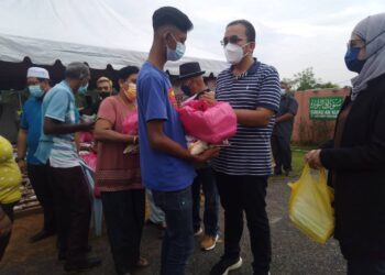 MOHD. Rafiq Naizamohideen (dua dari kanan) menyampaikan sumbangan Deepavali Melaka Prihatin kepada masyarakat India di Taman Tambak Paya Permai di Ayer Molek, Melaka. - UTUSAN/MUHAMMAD SHAHIZAM TAZALI
