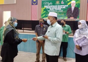 IDRIS Ahmad menyampaikan sumbangan kepada mangsa banjir di Bukit Gantang hari ini. - UTUSAN/WAT KAMAL ABAS