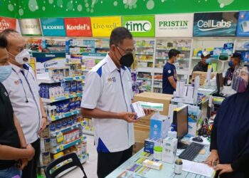 ROSOL Wahid (dua dari kanan) meninjau harga kit ujian Covid-19 yang dijual di farmasi di pusat beli-belah AEON Bandaraya, Melaka. - UTUSAN/MUHAMMAD SHAHIZAM TAZALI