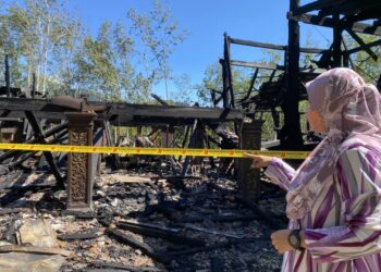 AZMITA Ahmad melihat keadaan rumahnya yang hangus terbakar di Kampung Perik, Kuala Nerang, Padang Terap semalam. - UTUSAN/NUR ANATI