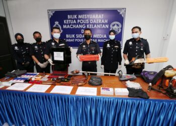 GANTI Jimmy (dua dari kiri) menunjukkan barangan dirampas lelaki yang pecah tabung masjid di Kampung Laklok, Machang dua minggu lalu. - UTUSAN/ROHANA MOHD. NAWI