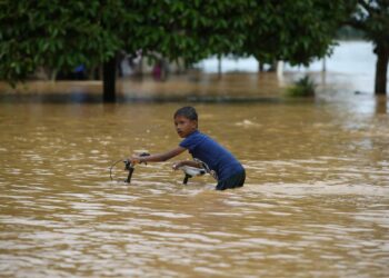 SEORANG kanak-kanan mengambil kesempatan bermain air dalam kejadian banjir di Kampung Kubang Betong,. Changlun, Kubang Pasu hari ini. - UTUSAN/ SHAHIR NOORDIN