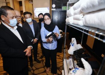 AMINUDDIN Harun mendengar taklimat selepas merasmikan pelancaran Linen Management System  di Port Dickson hari ini.-UTUSAN/MOHD SHAHJEHAN MAAMIN.