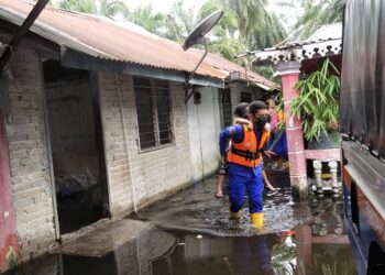 ANGGOTA APM membantu mengeluarkan mangsa banjir di Kampung Batu 7 ½, Lorong Mesra, Changkat Jong dekat Teluk Intan hari ini. - UTUSAN/IHSAN APM