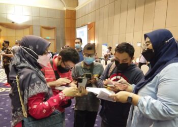 PENTERJEMAH bahasa isyarat dan pegawai Perkeso memberi penerangan kepada peserta OKU yang hadir ke Karnival Kerjaya Inspirasi OKU 2021 di Seremban hari ini.-UTUSAN/NOR SHAFAWATI YUP.