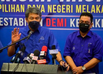 MOHAMAD Hasan (tengah) diiringi Sulaiman Md. Ali (kanan) bergambar bersama buku Manifesto BN di Seri Chendana Ballroom & Cafe, Taman Botanikal Melaka. - UTUSAN/AMIR KHALID