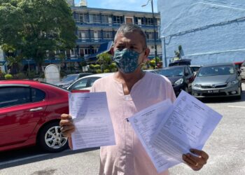 MOHD. YUSUF Abu Hasan menunjukkan laporan polis dibuat di Balai Polis Melaka Tengah, Banda Hilir, Melaka. - UTUSAN/DIYANATUL ATIQAH ZAKARYA