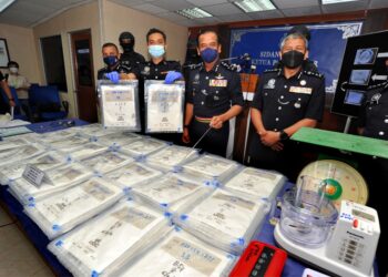 RAZARUDIN Husain (tiga dari kanan) menunjukkan dadah jenis heroin yang berjaya dirampas bernilai RM1.9 juta sambil diperhatikan Ayob Khan Mydin Pitchay pada sidang akhbar di IPK, Johor Bahru. -UTUSAN/RAJA JAAFAR ALI