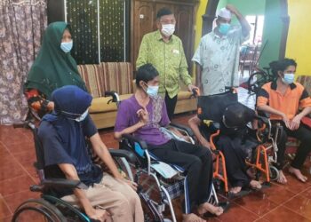 HANAFIAH Mat (berdiri tengah) melawat empat beradik yang lumpuh akibat sakit saraf di Kampung Teluk Kalong di Kemaman hari ini.