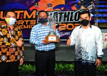 MOHD. Sazili Shahibi (tengah) mempamerkan piala pusingan UiSAT 2021 pada majlis perasmian kejohanan tersebut di Pusat Sukan UiTM hari ini. - UTUSAN / ABDUL RAZAK IDRIS