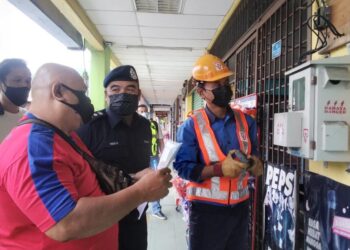 OSMAN Mamat (tengah) ketika operasi memotong bekalan elektrik di premis yang terlibat kegiatan perjudian di Taiping. - UTUSAN/WAT KAMAL ABAS