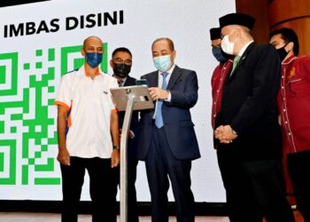 HAJIJI Noor (tiga kiri) melakukan gimik pelancaran aplikasi E-Jariah di Menara Kinabalu, Kota Kinabalu.