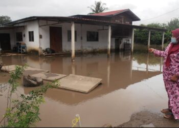 SAIDATUL Akma Che Din menunjukkan air yang memenuhi kawasan rumahnya susulan banjir termenung di Kampung Banggol Besi, Tanah Merah, Pendang. - UTUSAN/OTHMAN YAHAYA