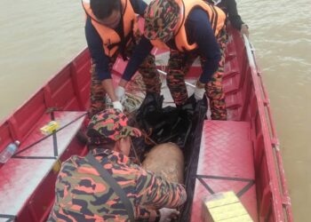 ANGGOTA Bomba membawa naik mayat mangsa ke dalam perahu ketika operasi mencari pagi tadi.