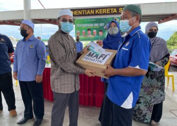 NIK Muhammad Zawawi Salleh (dua dari kanan) menyampaikan bantuan one-off dan Prihatin MAFI kepada salah seorang pemandu teksi di Pasir Puteh, hari ini. - UTUSAN/TOREK SULONG