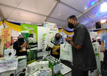 ROSOL Wahid (kanan) diberi penerangan mengenai produk yang dipamerkan oleh seorang peniaga yang menyertai Karnival Jualan Beli Barangan Malaysia sempena perasmian Kempen Beli Barangan Malaysia di Langkawi hari ini. - UTUSAN/NUR AMALINA AZMAN