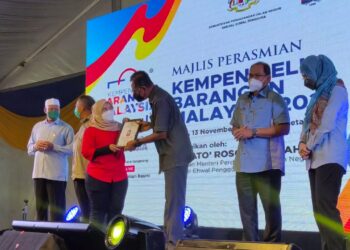 ROSOL Wahid (tiga dari kanan) menyampaikan sijil kedai harga patut kepada seorang peniaga pada majlis perasmian Kempen Beli Barangan Malaysia peringkat Kebangsaan di Dataran Chenang, Langkawi hari ini. - UTUSAN/NUR AMALINA AZMAN