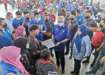 ISMAIL Sabri Yaakob (tengah) menyerahkan surat tawaran pengajian kepada Muhammad Daniel Hakimi Mohd Diya, 18, pada program ramah mesra di Bilik Gerakan DUN Sungai Udang, Tangga Batu, Melaka di sini hari ini. UTUSAN / RASUL AZLI SAMAD