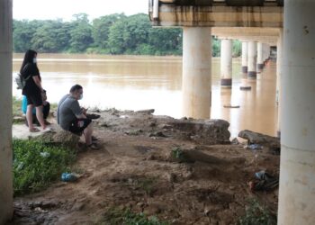 KELUARGA mangsa menunggu operasi mencari dan menyelamat dilakukan oleh pasukan bomba di tebing Sungai Kelantan, Kota Bharu hari ini. - UTUSAN/ROHANA MOHD. NAWI