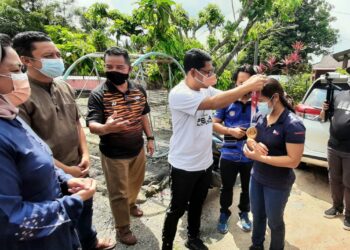 AHMAD FAIZAL Azumu mengalungkan semula pingat emas Sukan Olimpik acara angkat berat kepada Hidilyn Diaz di Kampung Kesang Tua, Jasin, Melaka. - UTUSAN/AMRAN MULUP