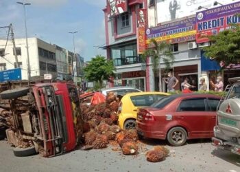 KEADAAN sebuah lori yang terbalik dan membabitkan muatan sawit sembilan tan bertaburan menimpa tiga buah kenderaan yang diparkir di Jalan Mewah, Bahau, Jempol pagi tadi.-MEDIA SOSIAL