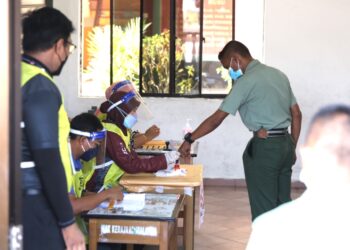 ANGGOTA tentera dikenakan dakwat kekal pada jari telunjuk sebelum mengundi pada hari mengundi awal sempena PRN Melaka di SK Terendak 2, Melaka. - UTUSAN/RASUL AZLI SAMAD