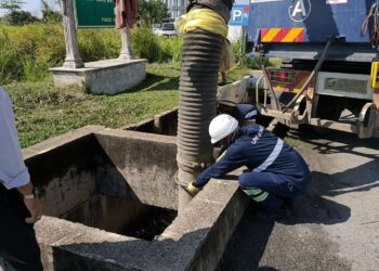 KERJA-KERJA pembersihan longkang yang dipenuhi sisa domestik giat dilakukan pihak Perbadanan Pengurusan Sisa Pepejal dan Pembersihan Awam (SWCORP) di beberapa taman perumahan di Kuantan, Pahang. - FOTO/UTUSAN/DIANA SURYA ABD WAHAB