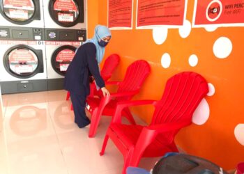 SEORANG pekerja menunjukkan contoh kerusi plastik yang dicuri dari kedai dobi milik Nadia Badrul Hisham di Kota Kubang Labu, Wakaf Bharum Tumpat hari ini. - UTUSAN/ROSLIZA MOHAMED