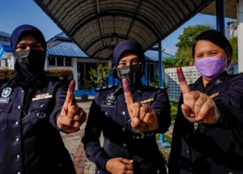 INSPEKTOR Fauzana Mohd. Razali (dari kiri), ASP Azita Ramli dan Inspektor Margaret Ena Mihos menunjukkan jari yang dikenakan dakwat kekal selepas selesai mengundi pada Hari Mengundi Awal bagi anggota polis dan tentera sempena Pilihan Raya Negeri Melaka di IPK Melaka, Bukit Beruang, Melaka. - UTUSAN/AMIR KHALID