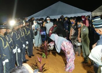 Ibu Allahyarham Mohamad Affendi Bustamy yang maut dalam nahas pesawat Hawk 108 milik Tentera Udara Diraja Malaysia (TUDM) menyiram air di kubur anaknya di Tanah Perkuburan Islam Muadzam Shah di Rompin, Pahang. - UTUSAN/SHAIKH AHMAD RAZIF