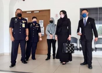 Nur Jawaheer Ismail atau dikenali sebagai Wawa (dua kanan) diiring keluar dari Mahkamah Majistret di Kota Kinabalu, hari ini.