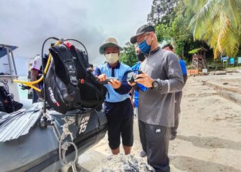 ABDUL Wahab Rahim (kiri) bersama Mohamad Ismail (kanan) melihat aset yang digunakan bagi operasi penyelaman pada Program Kesiapsiagaan APM Menghadapi Bencana Operasi Laut di Pulau Payar, Langkawi semalam. - UTUSAN/NUR AMALINA AZMAN