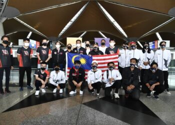 AHMAD Faizal Azumu (tengah berdiri belakang) bergambar bersama pasukan Todak dan SMG mewakili negara dalam Kejohanan Dunia M3 Mobile Legends: Bang Bang (MLBB) di Lapangan Terbang Antarabangsa Kuala Lumpur (KLIA). - UTUSAN/SITI AZIELAH WAHI