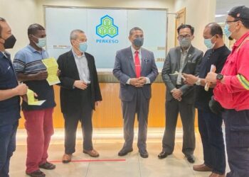 FUAD Alias (tiga dari kiri) dan Md. Fiah (tengah) menyampaikan faedah pencen penakat kepada empat wakil keluarga orang berinsurans yang meninggal dunia akibat Covid-19 di Pejabat Perkeso di Seremban hari ini.-UTUSAN/NOR SHAFAWATI YUP.