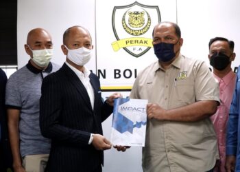 MOHAMMAD Yadzan Mohamed (kanan) menyerahkan dokumen sebagai simbolik penjualan saham Pafa kepada Pengurus IMC, Khairul Mahmood di pejabat Pafa di Ipoh kelmarin.- UTUSAN/ZULFACHRI ZULKIFLI