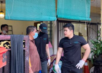 AKID Anuar (kanan) bertanya sesuatu kepada penduduk yang terlibat banjir di Ampang baru-baru ini.