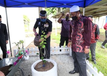 SHAFIEN Mamat menyiram pokok yang ditanam sebagai simbolik perasmian Surau Ar-Rasyidin di IPD Tumpat, hari ini. - UTUSAN/ROHANA MOHD. NAWI